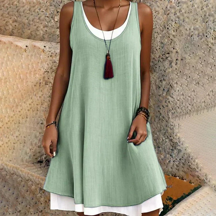 Stylish blue women's layered mini dress, sleeveless with a flattering scoop neck and swing style for summer fashion.