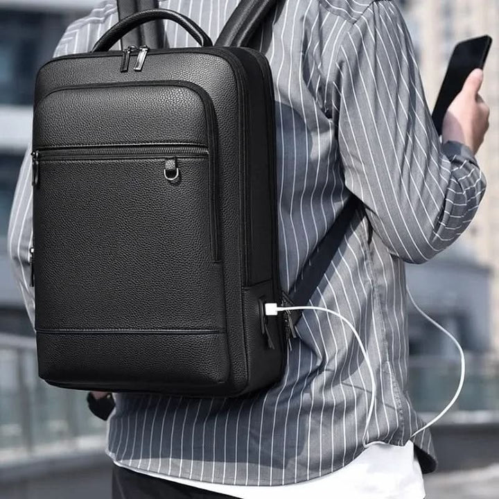 Durable PU leather work backpack with USB port, fits laptops for school or office, unisex style.