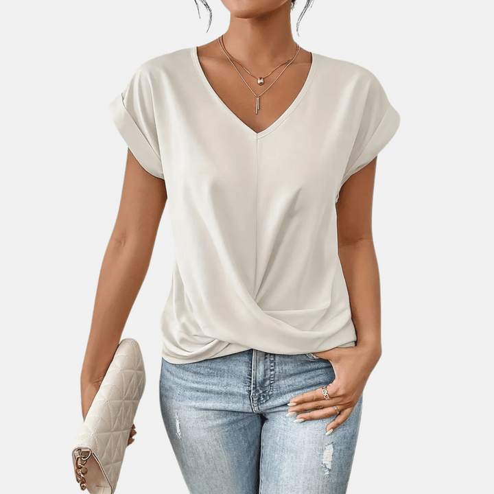 Stylish women's pullover V-neck top featuring a modern draped hem. Short sleeve for spring & summer.
