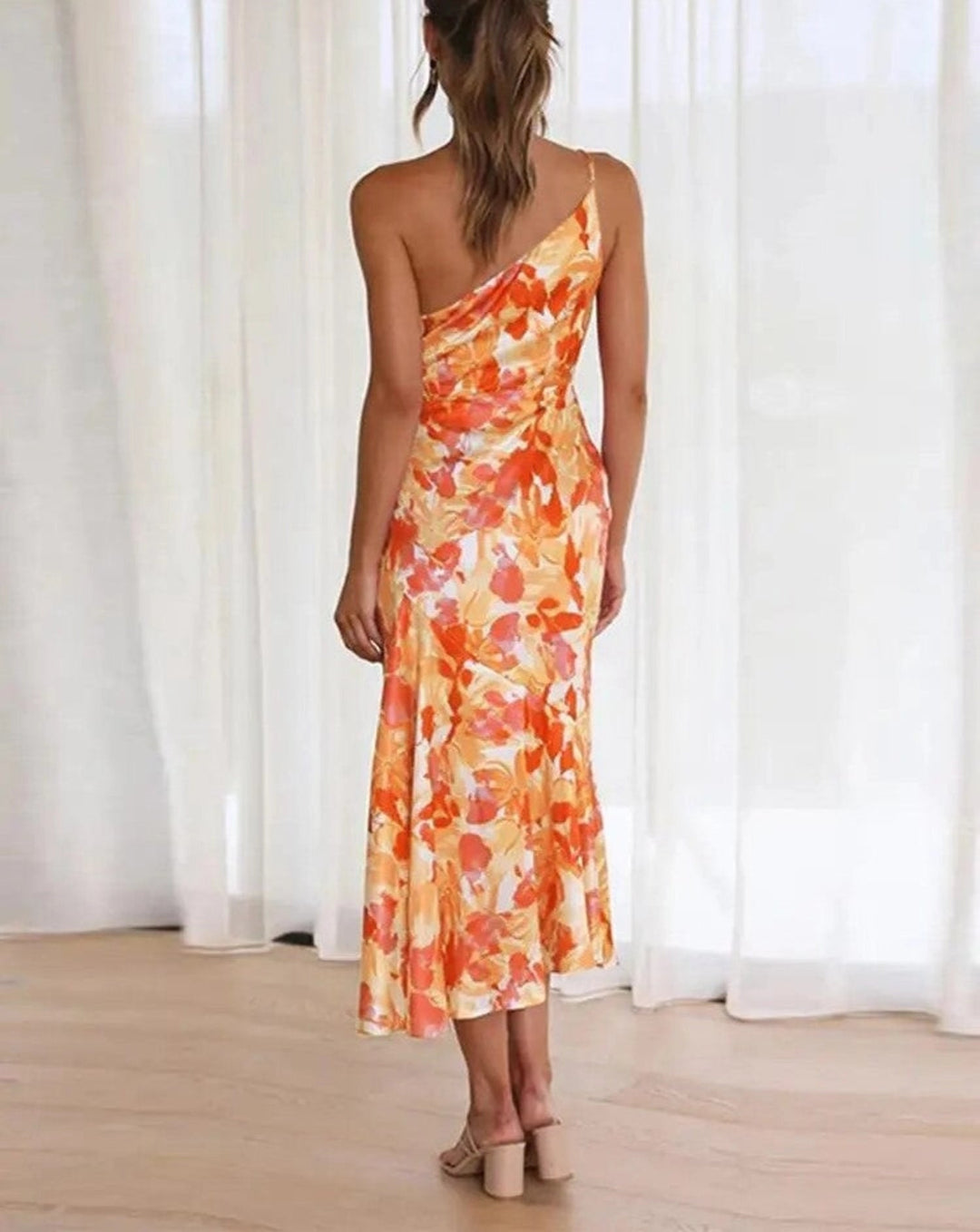 Summer-ready women's floral midi dress, flowing fabric and modern asymmetric sleeveless style.