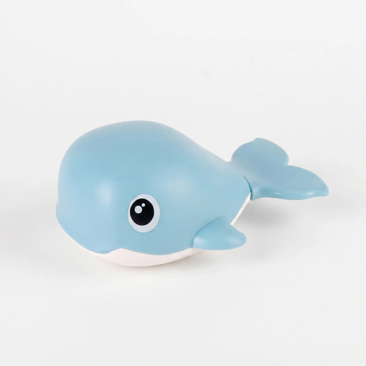 Toddler playing with a durable, battery-free floating whale bath toy during fun water time. Wind-up action.