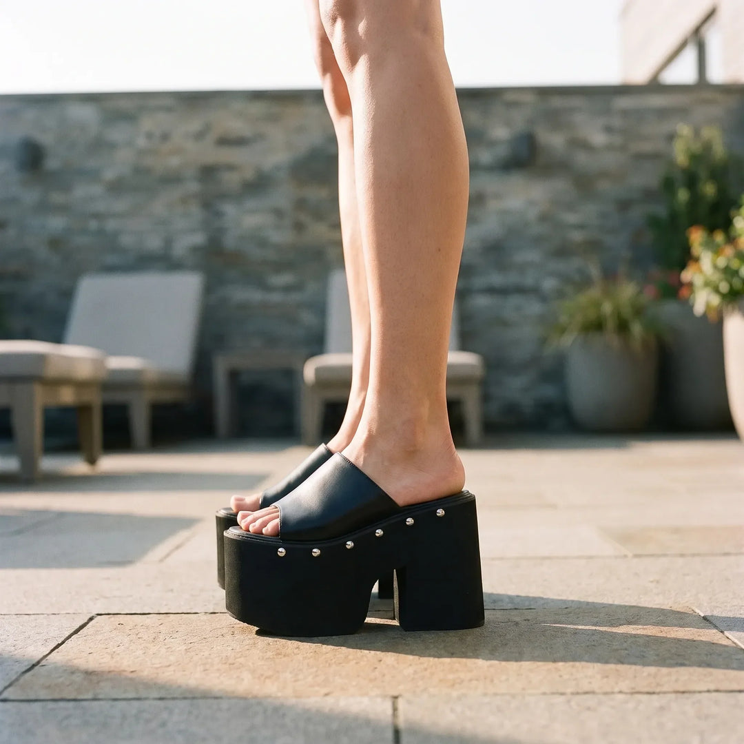 Women's black platform sandals with a bold block heel, chunky sole, and open toe for summer fashion.