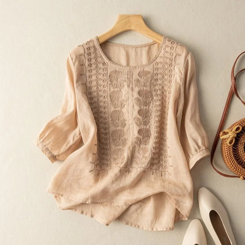 Women's romantic sheer puff sleeve blouse with intricate embroidery. Elegant round neck, three-quarter sleeves.