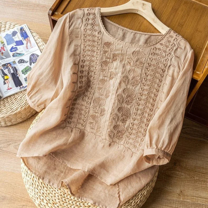 Women's vintage-inspired sheer puff sleeve blouse. Embroidered round neck, three-quarter sleeves, romantic top.