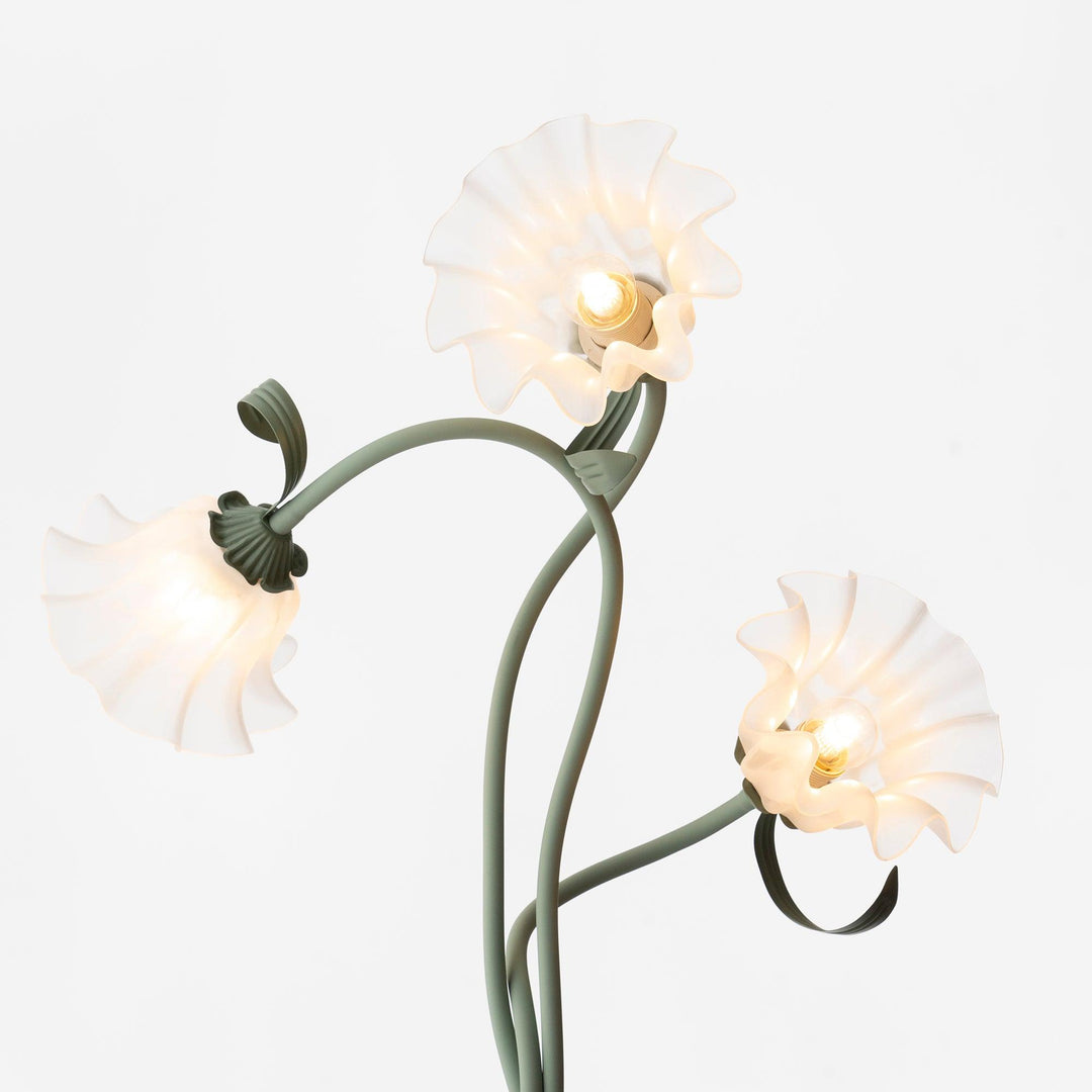 Modern green floor lamp with delicate floral patterns and a classic white shade.