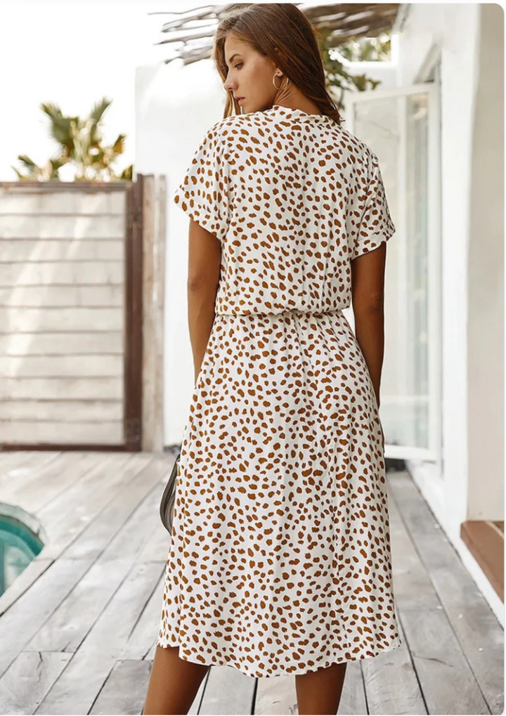 Stylish V-neck spotted midi dress with short flutter sleeves, offering comfortable & chic look.