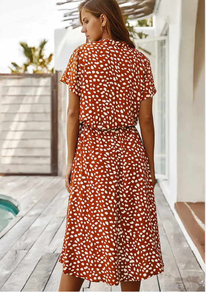 Front view: Women's button-down spotted midi dress, highlighting relaxed fit and elegant drape.