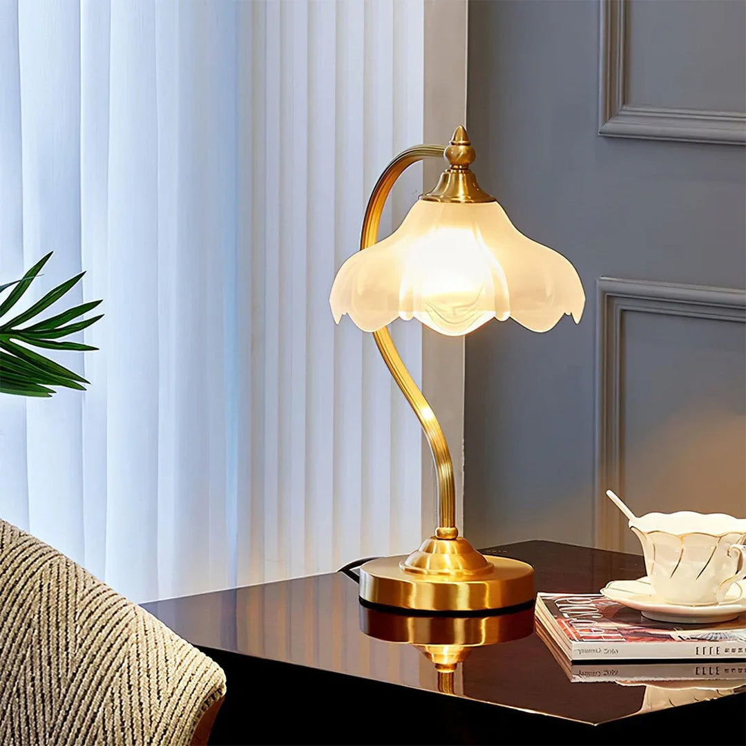 Elegant dimmable table lamp with floral glass shade & shimmering gold brass details.