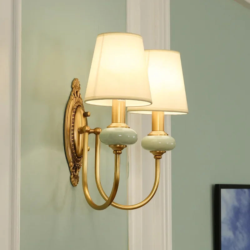 Antique bedside wall sconce with copper and ceramic details, providing warm ambient light.