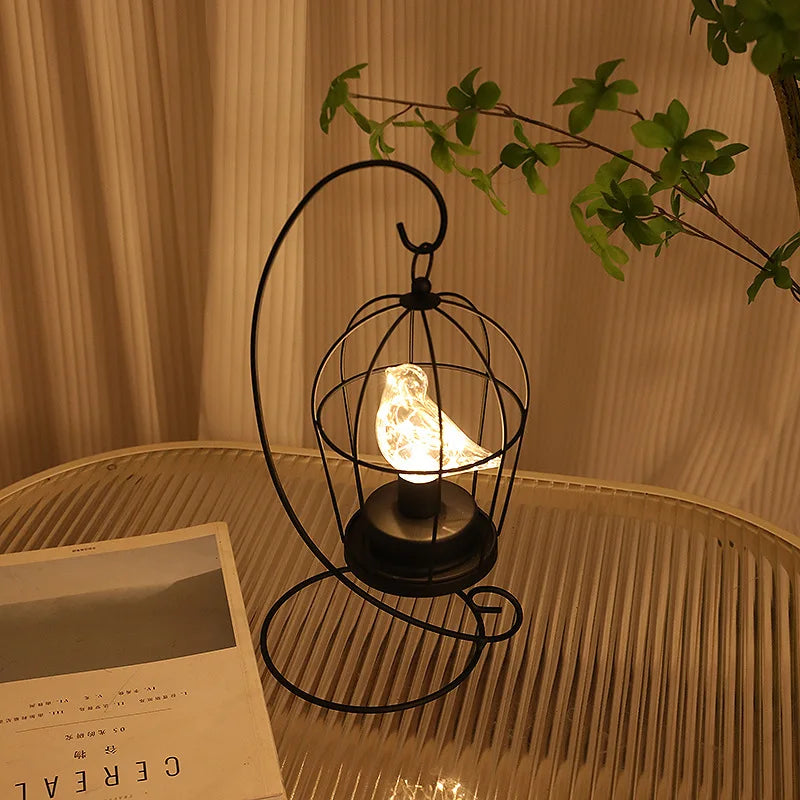 Elegant birdcage LED table lamp provides warm glow. USB/battery powered. A unique decorative gift for home decor.