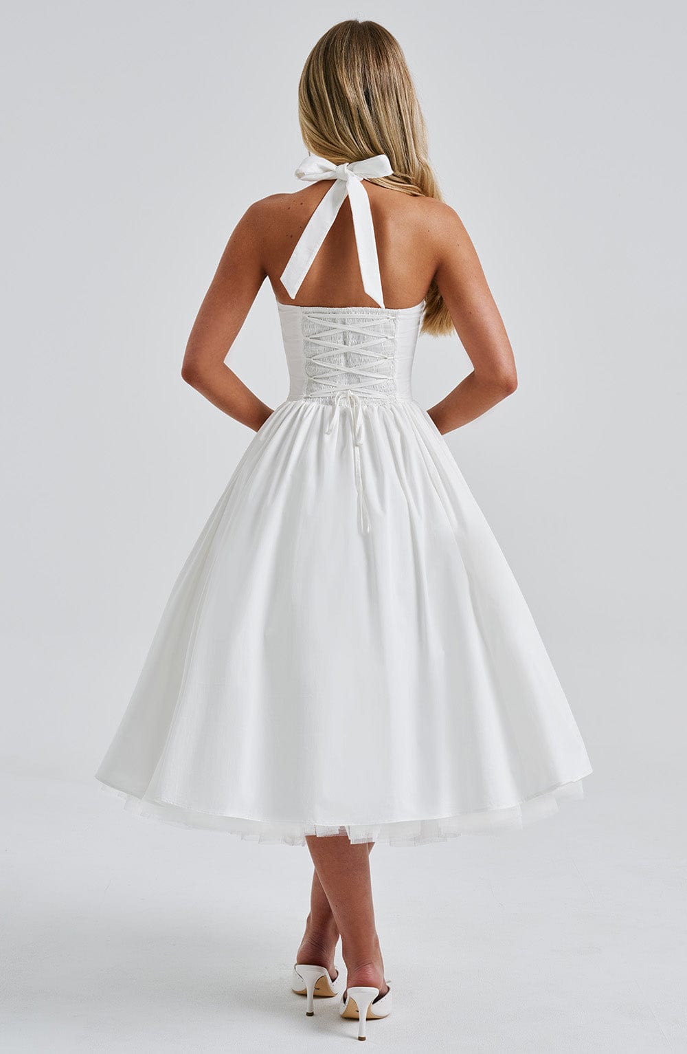 Front detail of black and white halter midi dress, tailored waistline for wedding guest and event wear