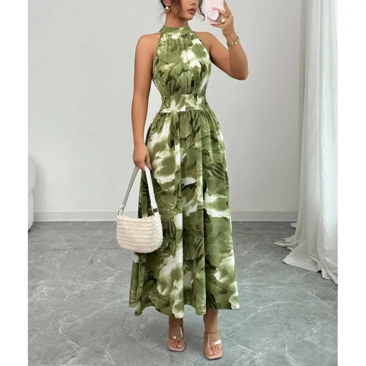 Women's halter neck maxi dress with smocked waist & vibrant abstract pattern, perfect for summer elegance.