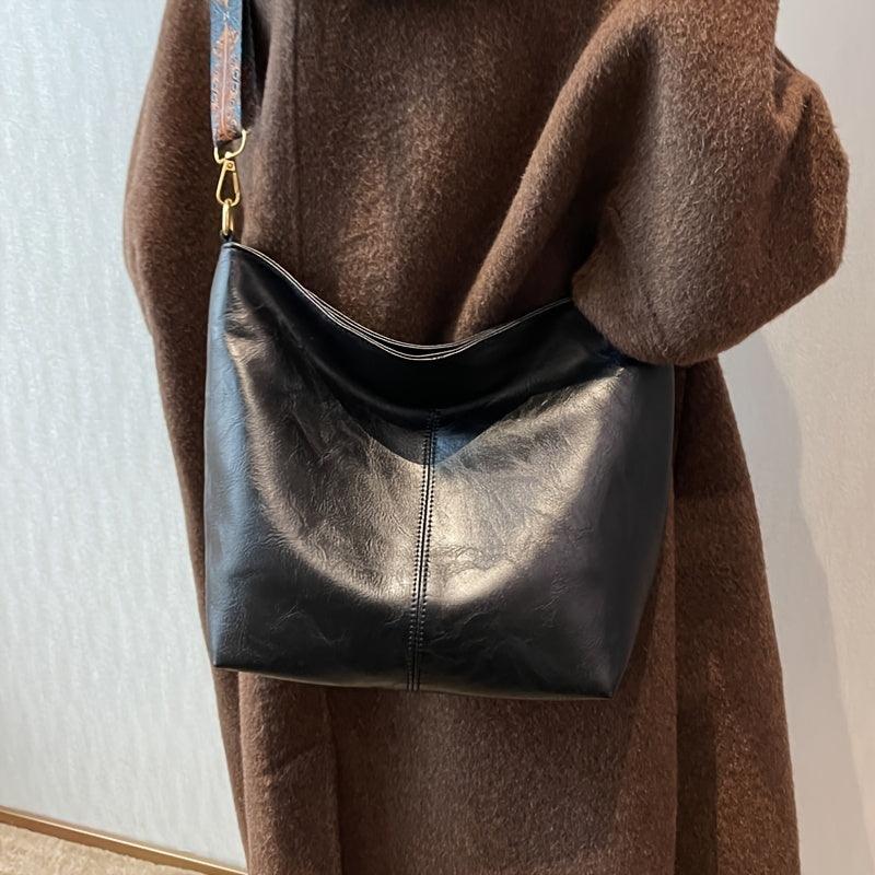 Angled shot: Chic women's hobo shoulder bag, showcasing its patterned strap. Bohemian everyday carry.