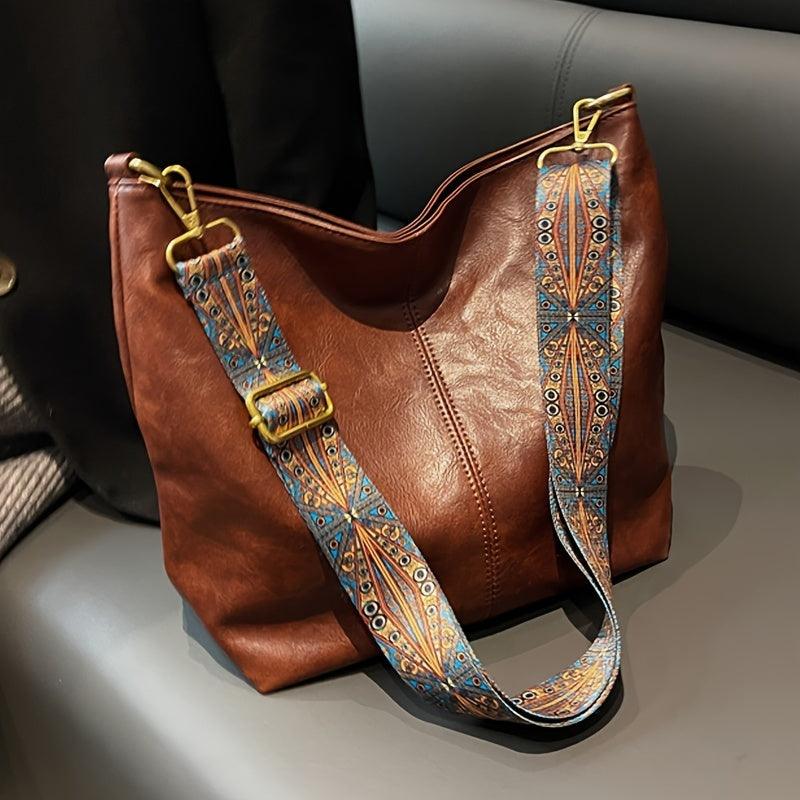 Woman models a stylish bohemian hobo shoulder bag with a vibrant patterned strap. Everyday chic accessory.