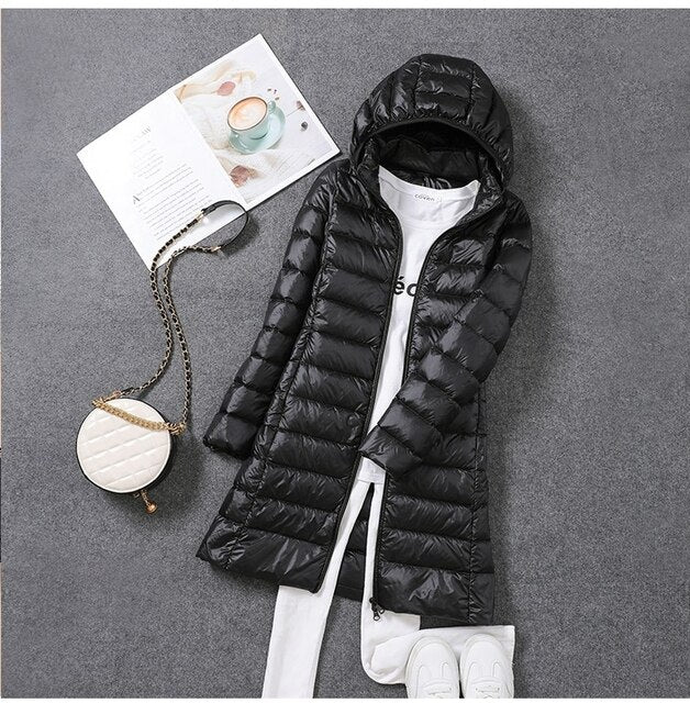 New women's long hooded puffer jacket, perfect for cold weather & ultimate winter warmth. Cozy fashion.