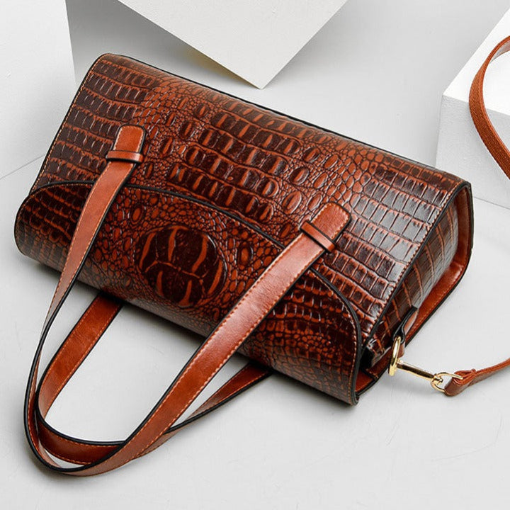 Sophisticated burgundy women's handbag with intricate crocodile print. A stylish and elegant shoulder purse.