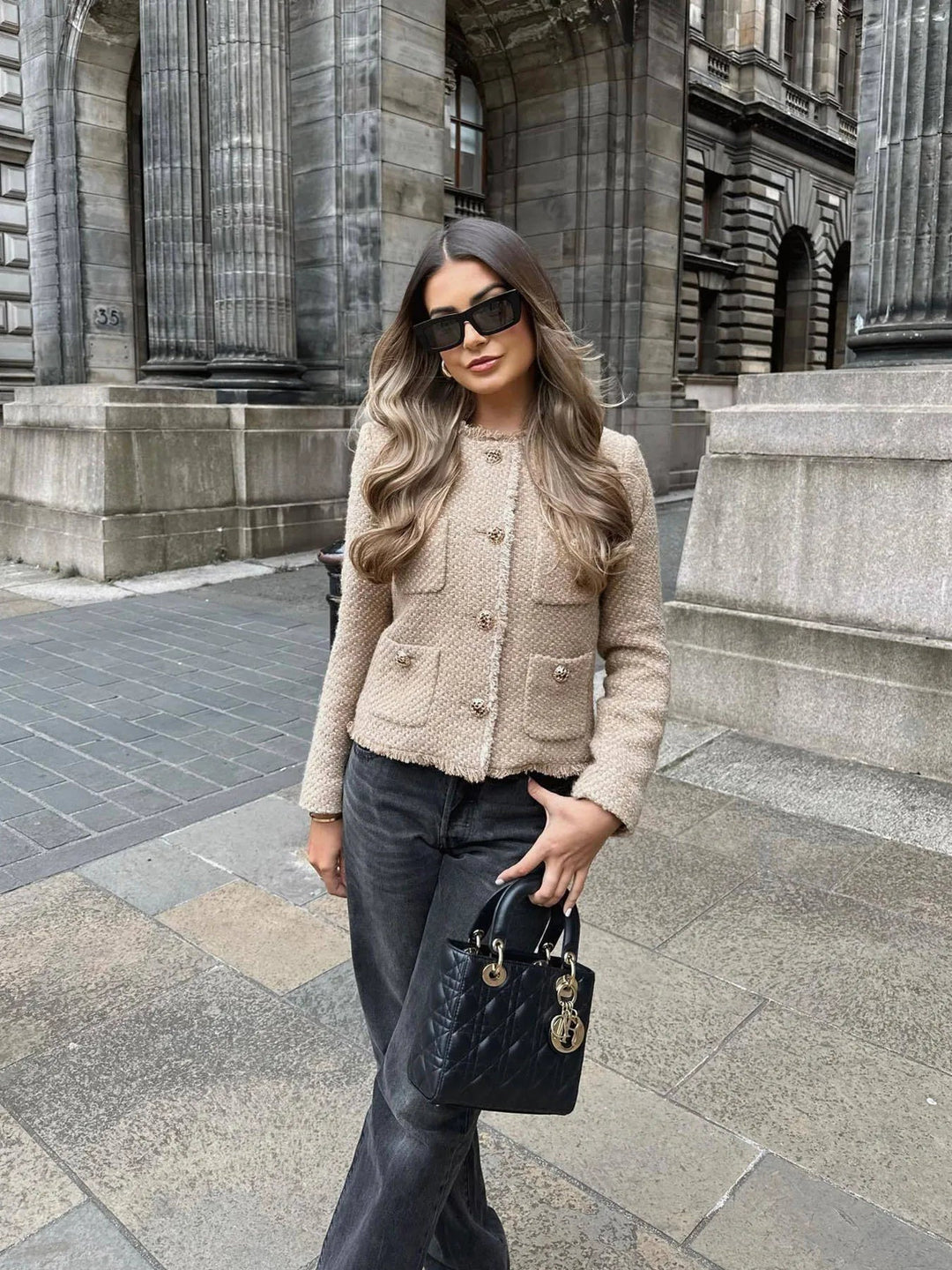 Fashionable women's tailored cropped jacket featuring unique fringed accents, great for fall style.