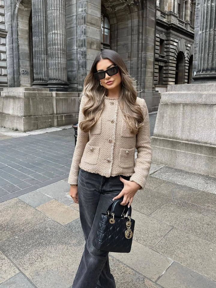 Fashionable women's tailored cropped jacket featuring unique fringed accents, great for fall style.