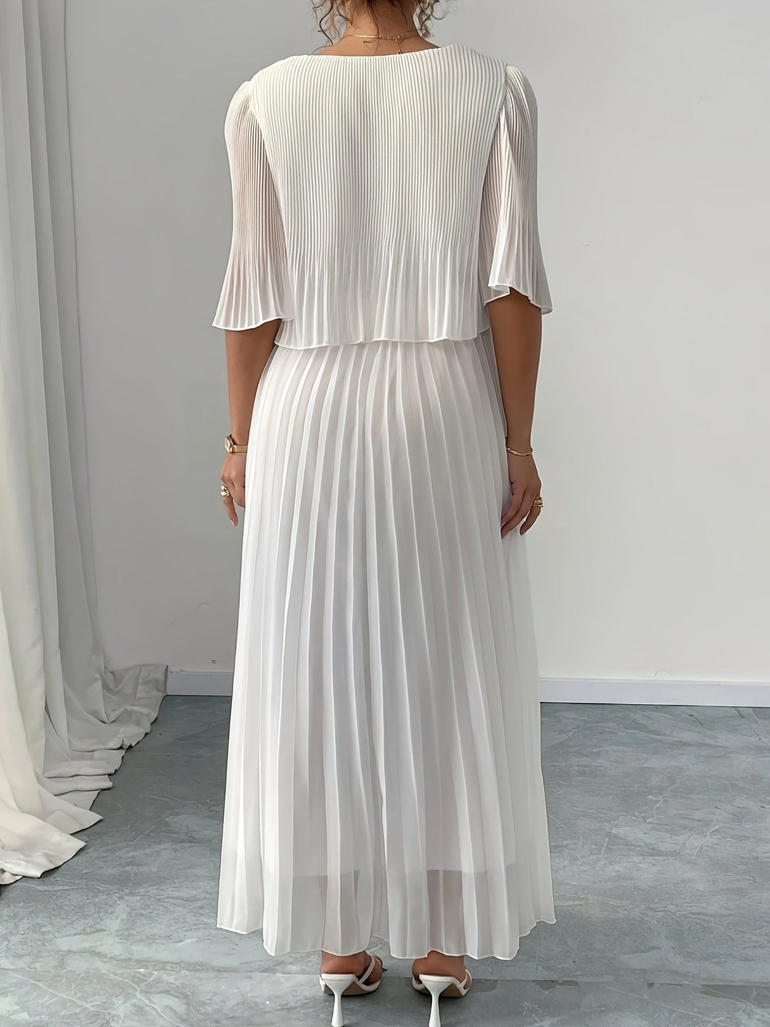 Long white pleated A-line formal dress for women, ideal as an elegant wedding guest or party gown.