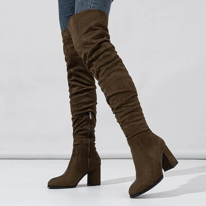 Model wearing black heeled over-the-knee boots, demonstrating their flattering fit and style.