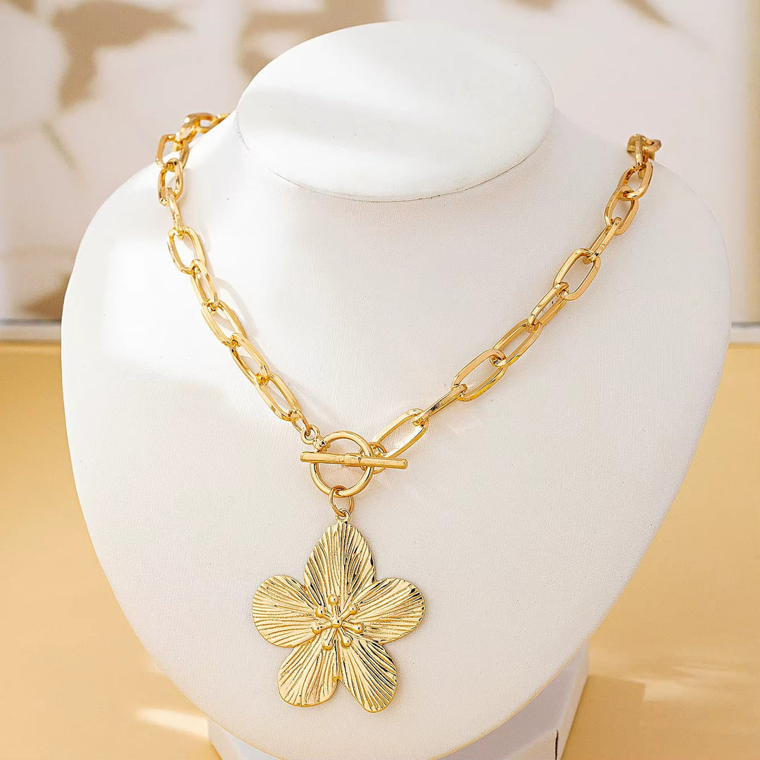 Women's textured wisteria flower pendant necklace. Gold-tone floral charm offers a unique vintage style statement.