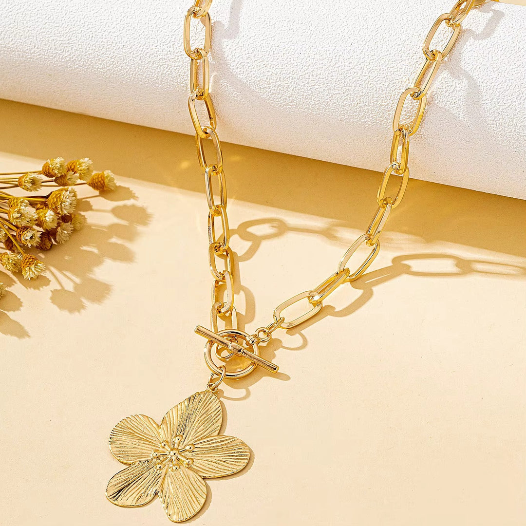 Vintage-style wisteria flower pendant necklace for women. Features a textured gold-tone floral charm, t-bar closure.