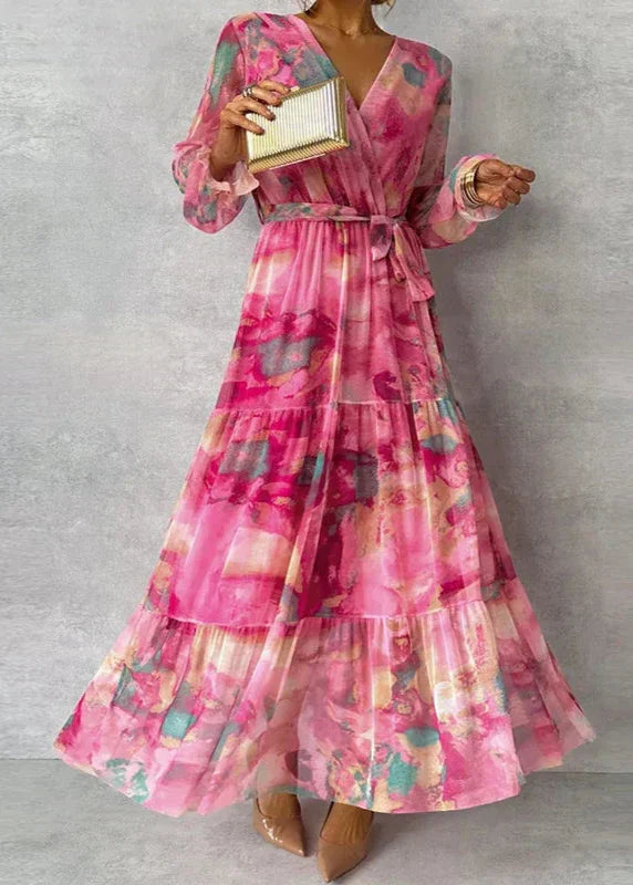 Elegant pink floral wrap maxi dress for women, featuring a flattering V-neck, long sleeves, and a flowy tiered skirt.