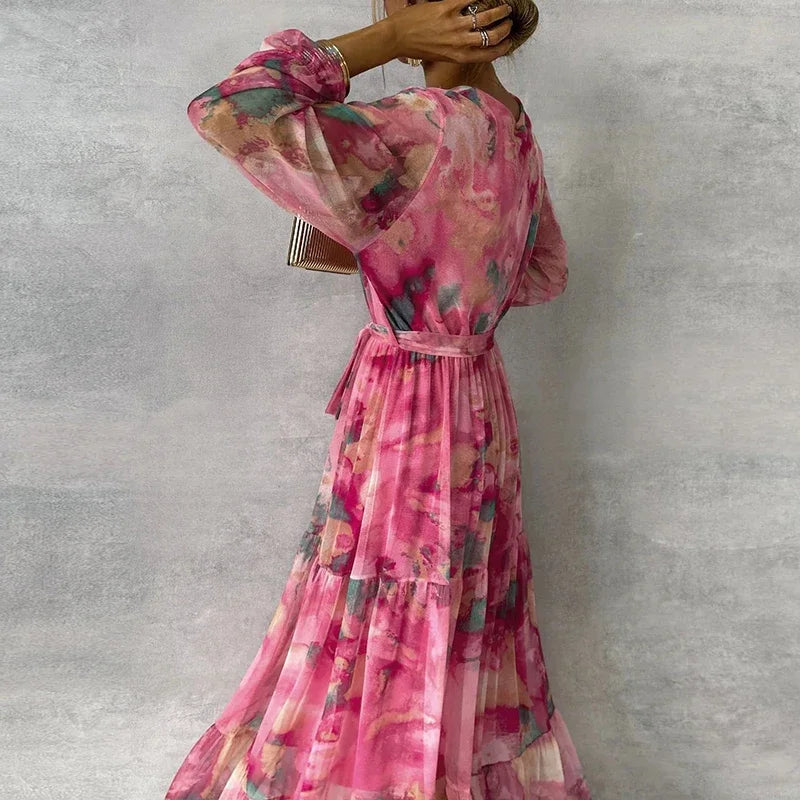 Sophisticated women's pink floral V-neck wrap maxi dress, perfect for occasions, with elegant long sleeves & tiered skirt.