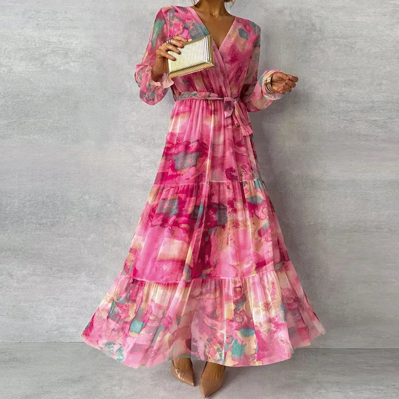 Flowy women's floral wrap maxi dress in pink, featuring a stylish V-neck, long sleeves, and a beautiful tiered skirt.