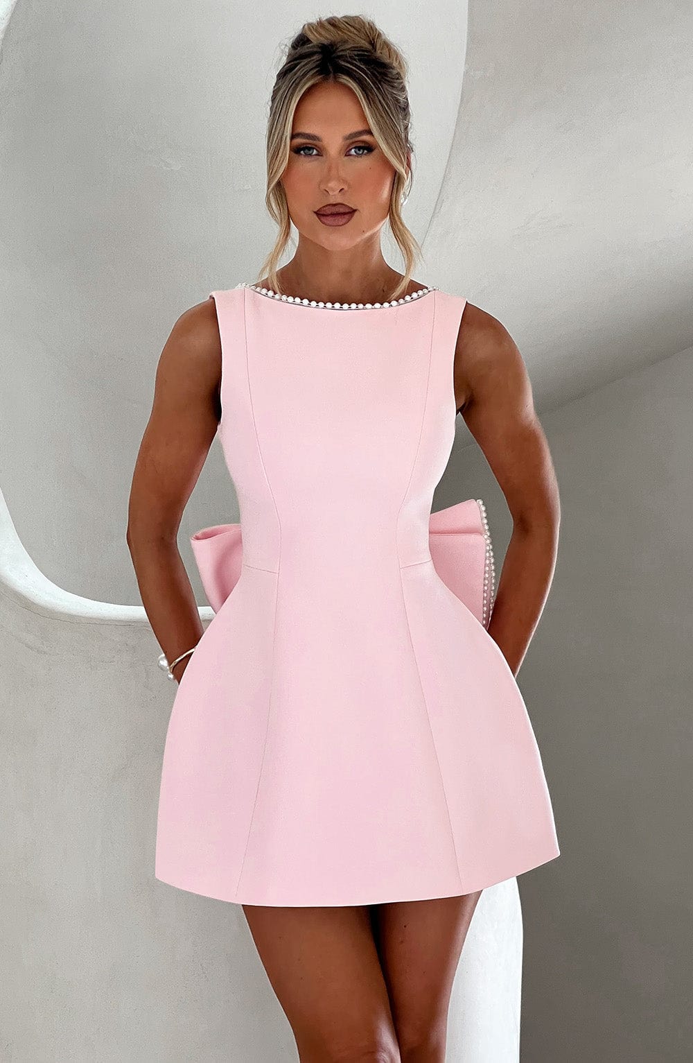 Elegant structured pink mini dress for women, ideal for a wedding guest or cocktail event.