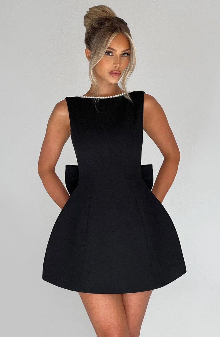 Close-up of the structured fabric detail on a women's elegant mini dress in pink.