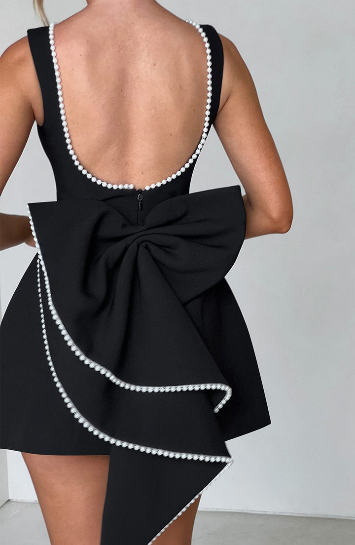 Pink structured mini dress for women, styled with accessories for a cocktail party.