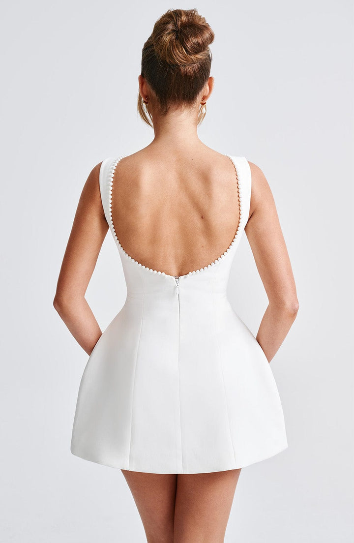 Detailed shot of the clean lines and tailored structure of a women's black mini dress.