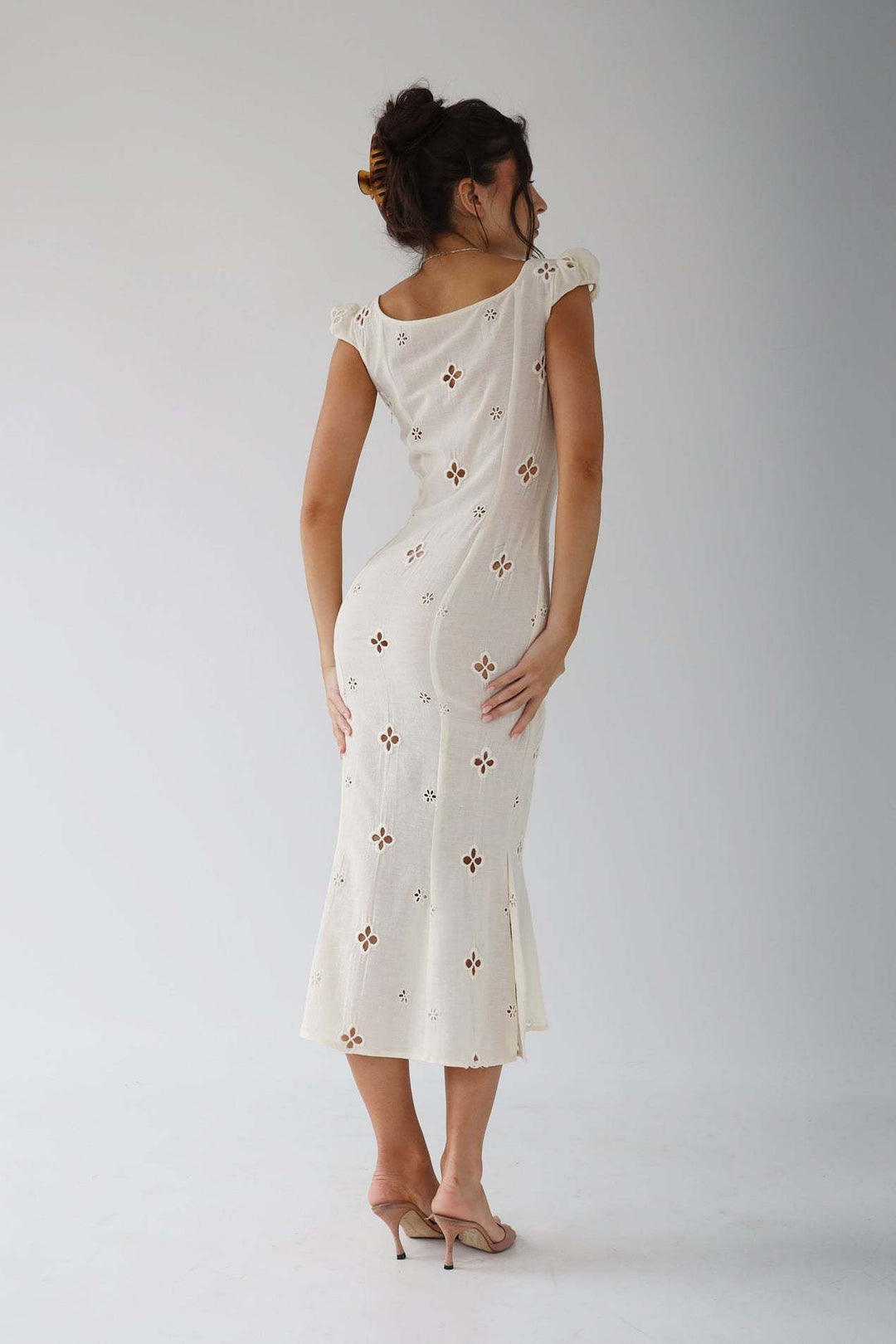Close-up of the fabric detail on an elegant white midi dress for women's special events.