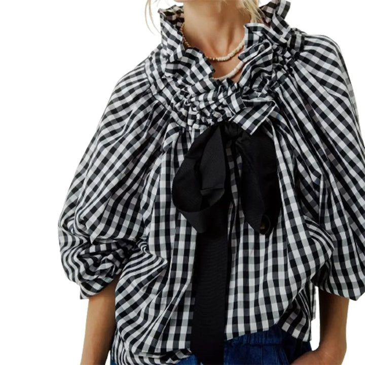 Detailed view of the cuffs on the puffed lantern sleeves of an elegant white women's blouse.