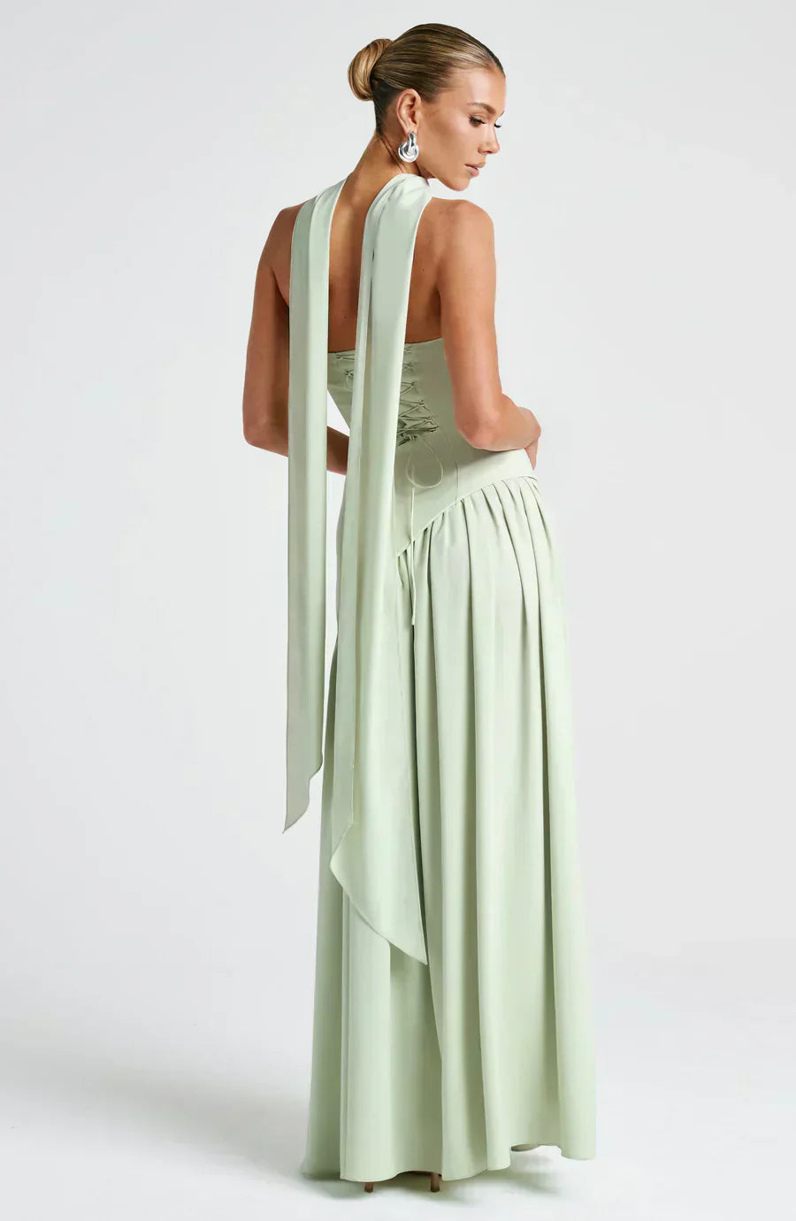 Back view of a women's black asymmetric maxi dress, showcasing its long, flowing silhouette, wedding guest.