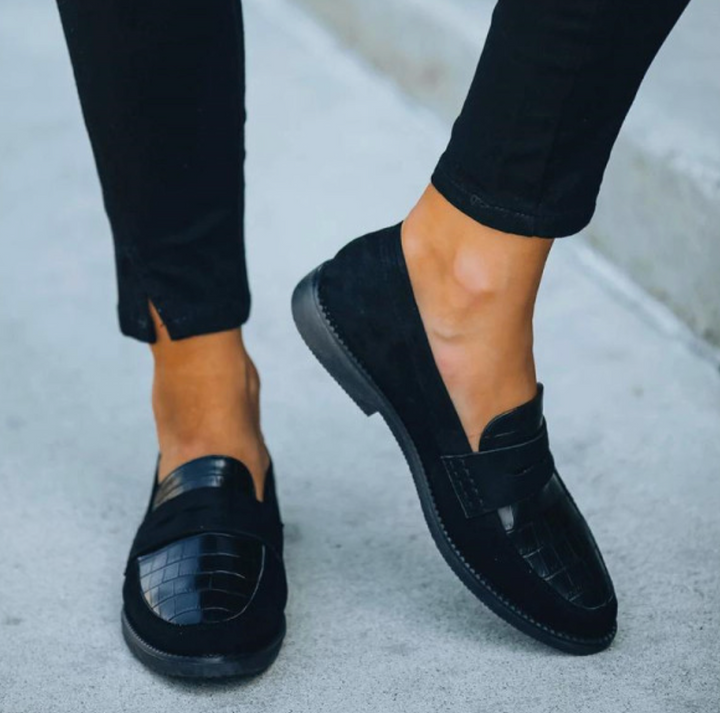 Chic women's black slip-on loafers with sophisticated croc-embossed detail. Elegant & versatile flat shoes.