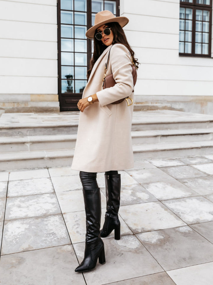 Stylish women's long trench coat with double-breasted front and wide lapels, ideal outerwear.