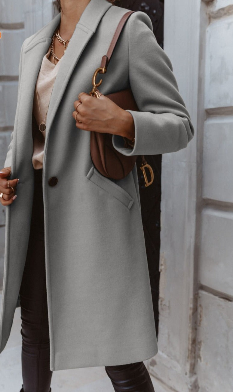 Close-up of the fabric texture on a women's long trench coat, a high-quality double-breasted outerwear.