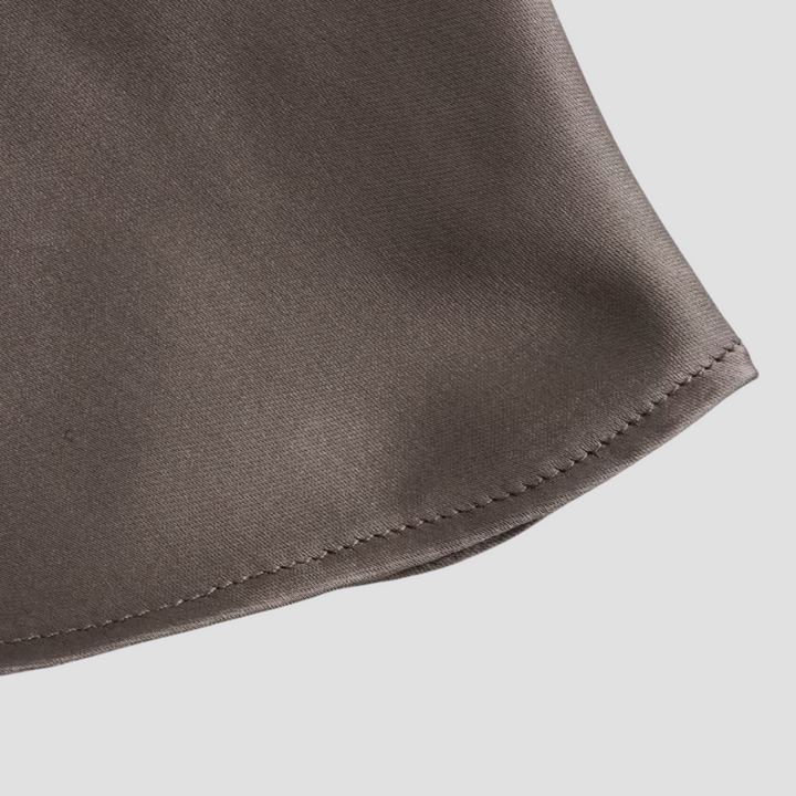 Close-up of a women's draped halter satin tank, showcasing the luxurious fabric and neckline detail.