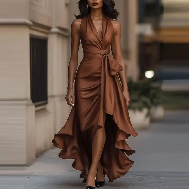 Full-length view of a women's flowing halter maxi dress, showcasing its elegant high-low hem.