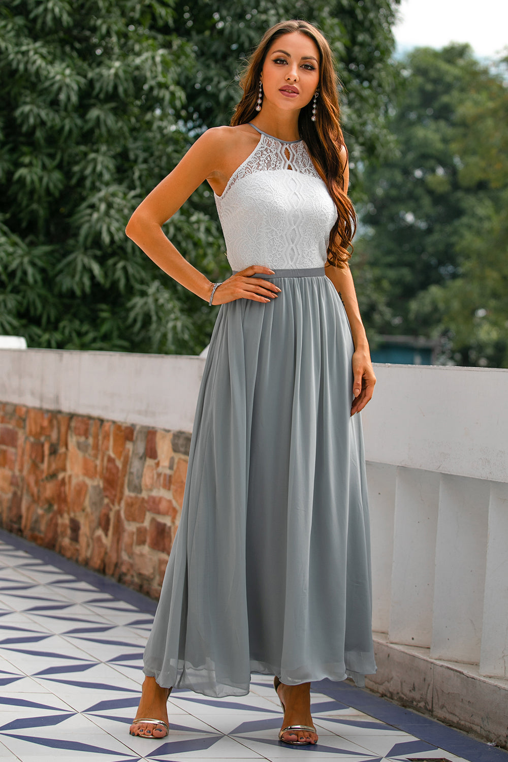 Side profile of a woman in a graceful halter neck maxi dress, highlighting its elegant drape.