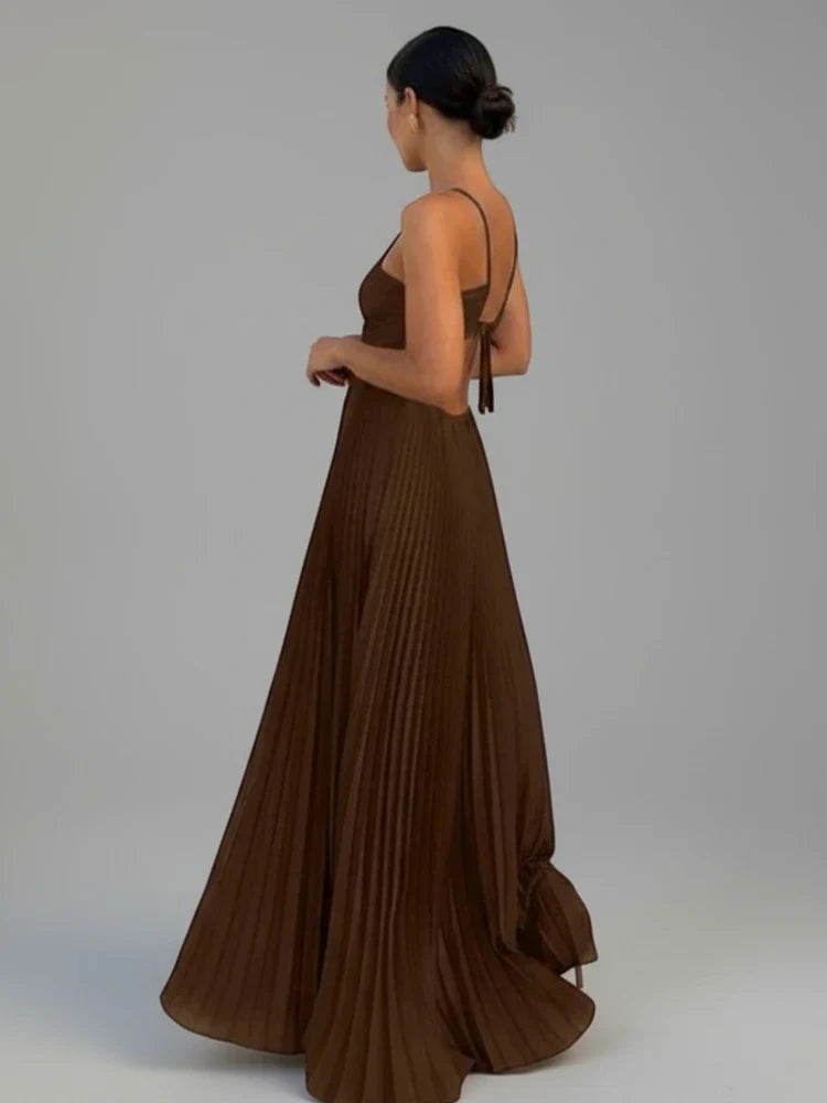Yellow women's pleated A-line maxi dress with elegant backless design. Flowy summer special occasion gown.