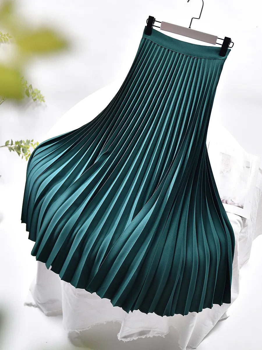 Woman wearing a long pleated maxi skirt paired with a casual top, demonstrating versatile spring fashion