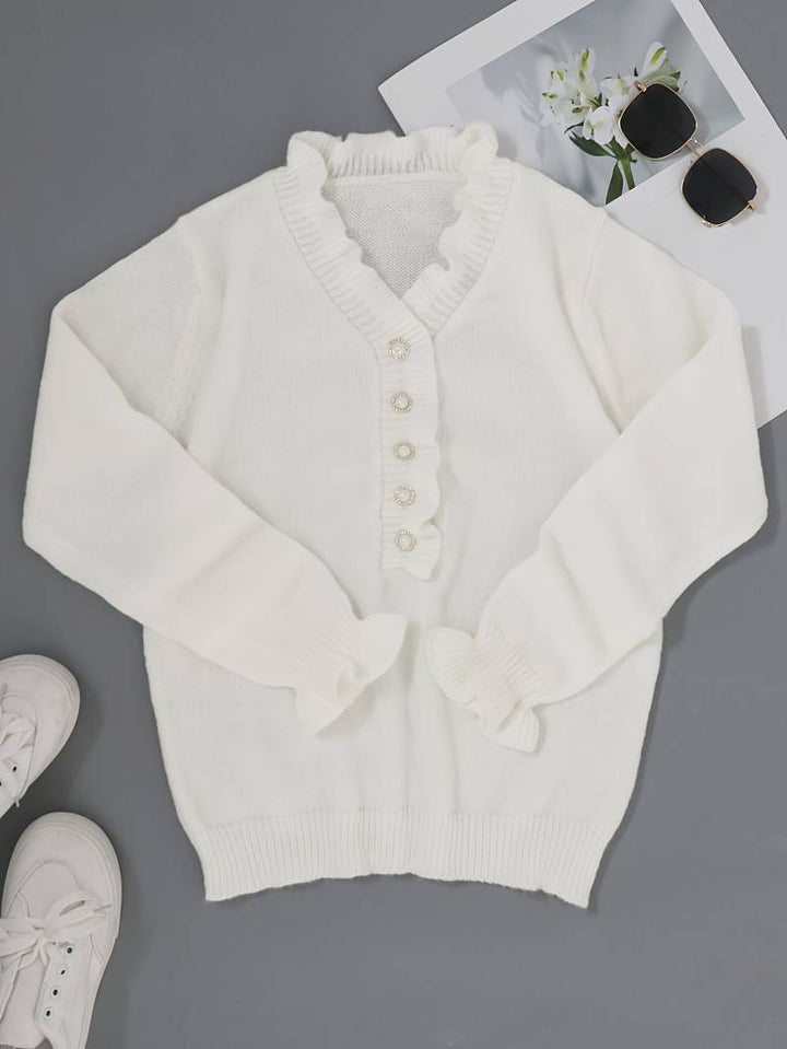 Close-up of a women's fashion blouse with intricate ruffle details and decorative buttons.