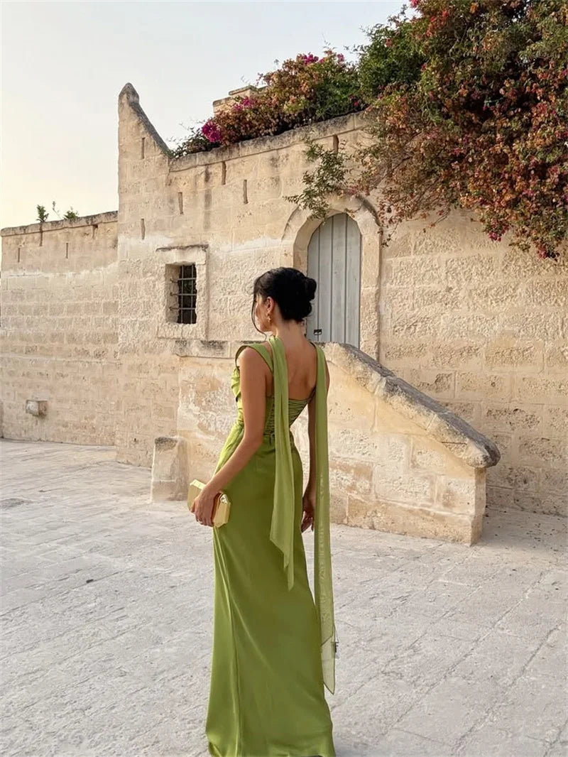 Long sleeveless wedding guest dress with a flowing maxi skirt and delicate details.