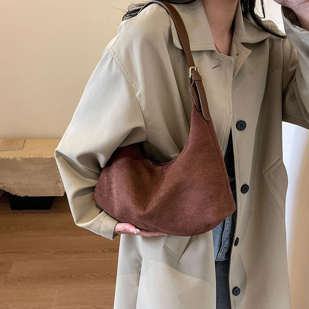 Minimalist black suede crescent shoulder bag for women, an elegant accessory and versatile handbag.