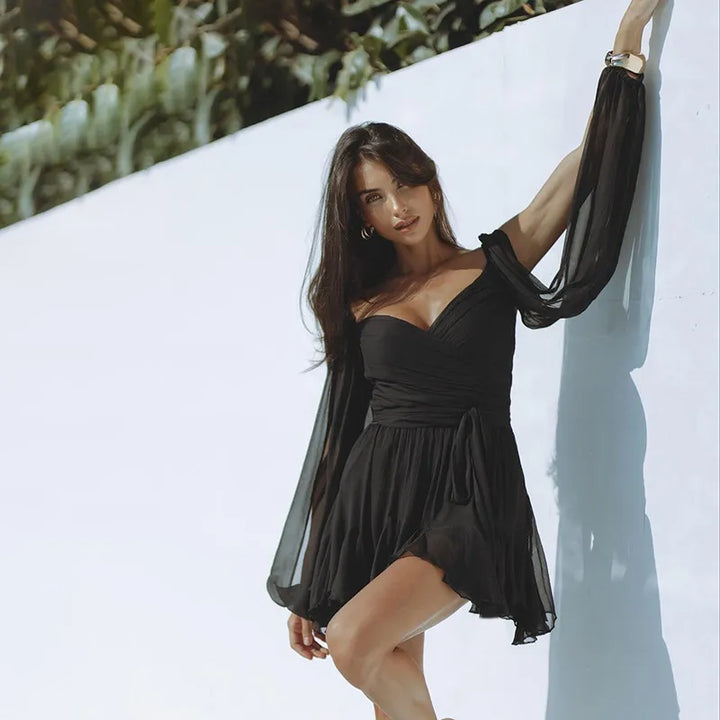 Front shot of a woman wearing a stylish long sleeve summer mini dress, showing its flattering silhouette.
