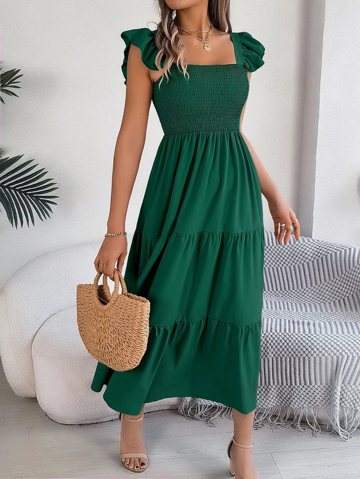 Women's smocked tiered midi dress with ruffled sleeves, offering an elegant & flowy casual chic look.