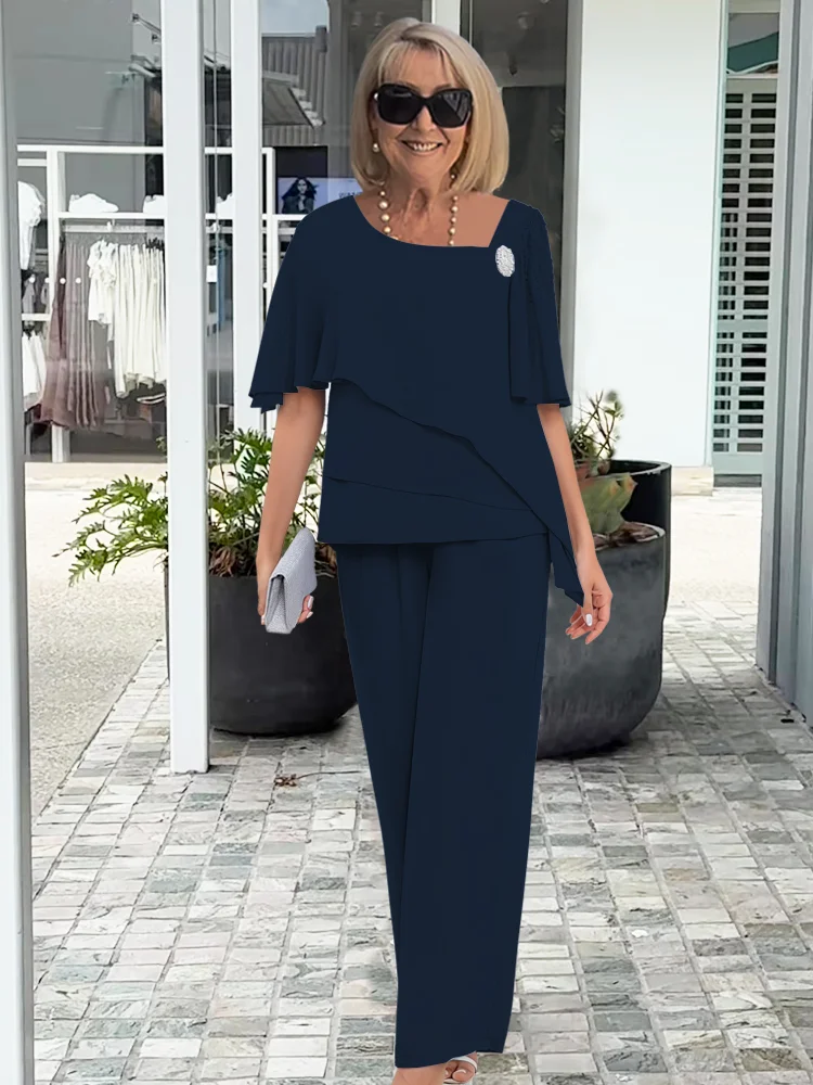 Chic women's formal wear set featuring a flowy cape top and tailored trousers for an elegant silhouette.